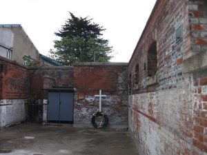 Memorial wreath at the wall where the shootings took place (from Irish Volunteers.org)